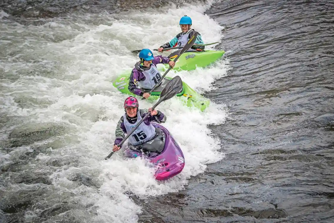 group surfing a kayak