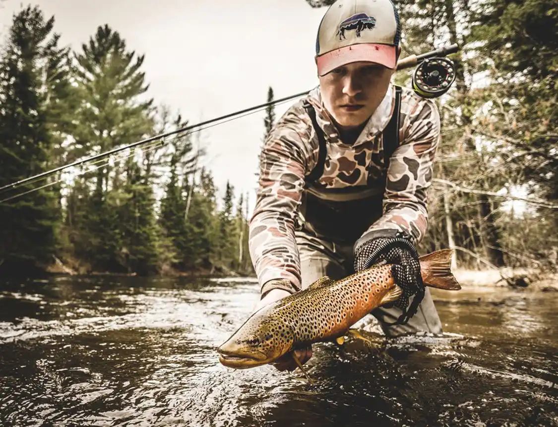 holding a brown trout in hand holding a brown trout in hand