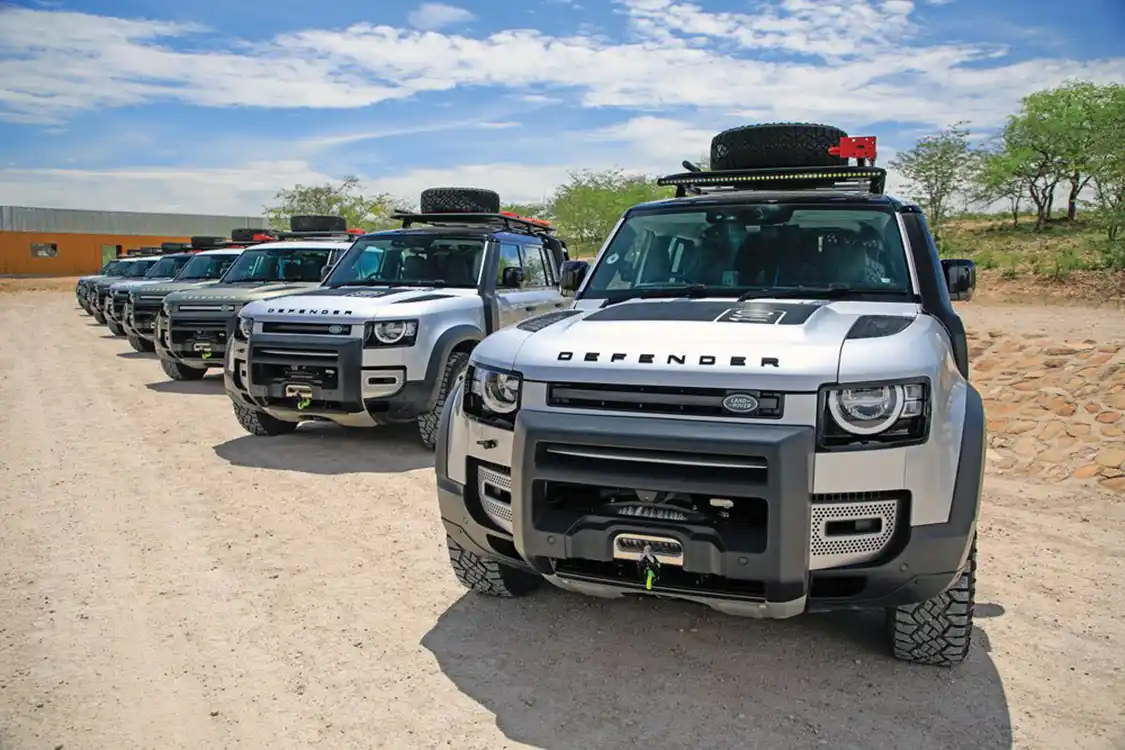 Land Rover Defenders lined up waiting for drivers