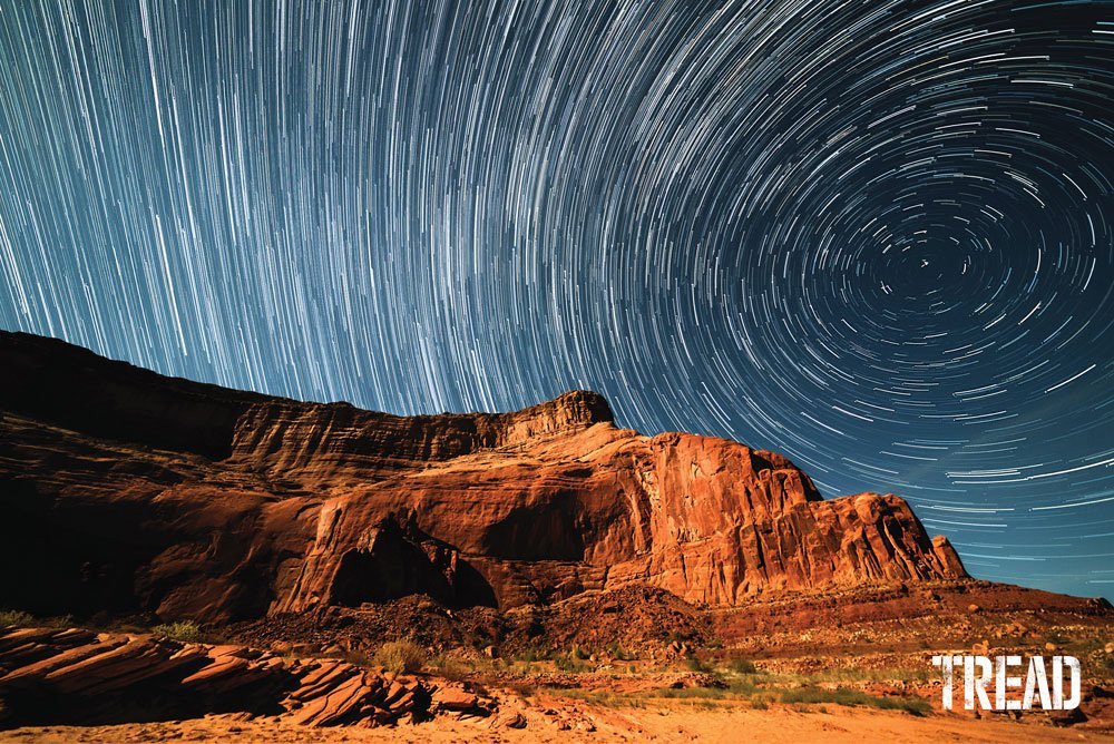 Time lapse of starry night sky against rock wall