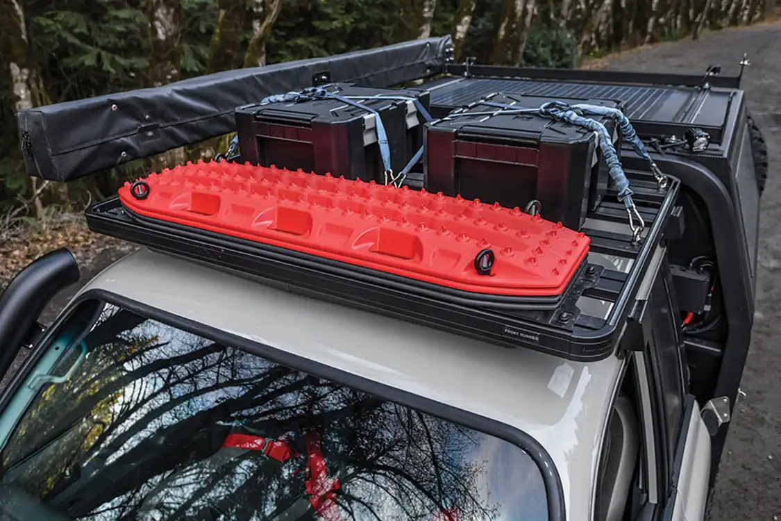 On top of the cab is a Front Runner Outfitters Slimline roof rack with Maxtrax and Front Runner Outfitters Wolfpack Pro boxes
