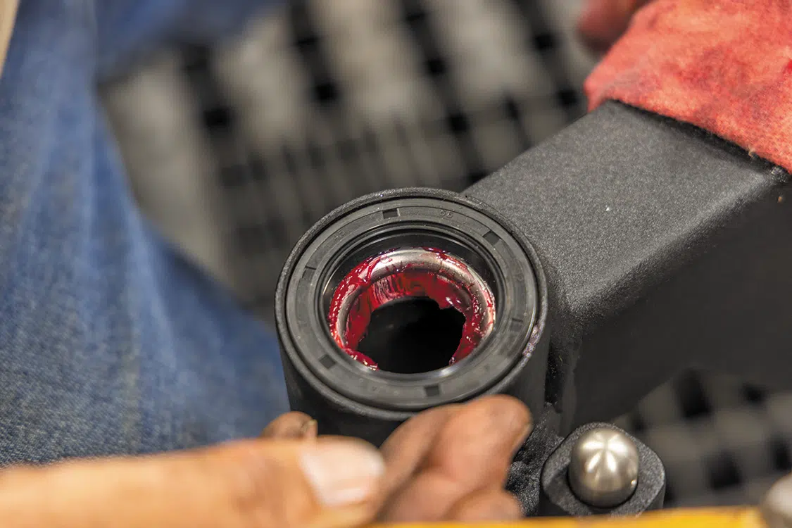 Pack the lower bearing with grease and install it in the swing arm