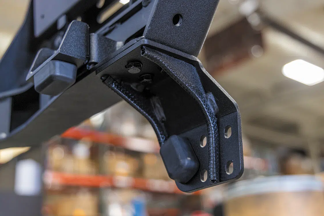 Attach latch mounting point and bump stops on the swing arm